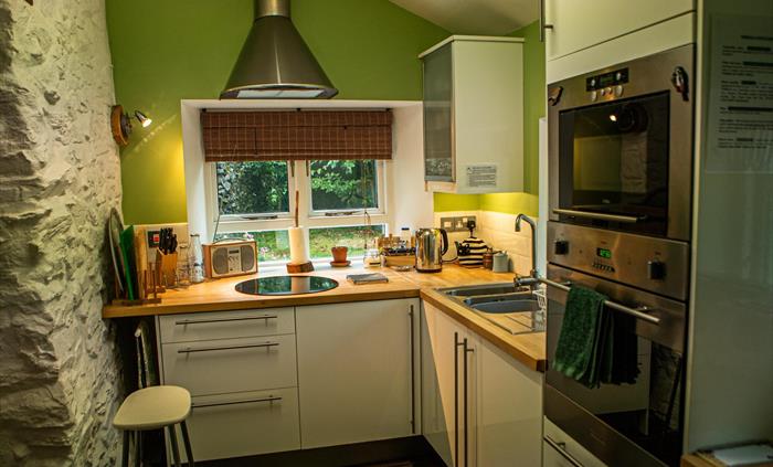 Hen Ffermdy cottage kitchen with oven, microwave hob, radio and essentials for cooking